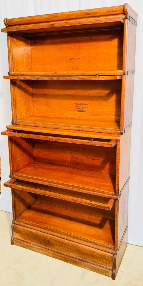 A six-piece antique oak modular barrister bookcase with four glass-fronted lifting doors and metal side straps. View X