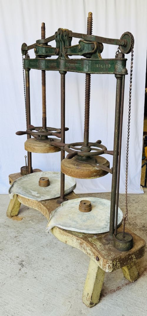 A Victorian double cheese press with a painted dark green cast-iron upper frame, twin screw spindles, and a heavy wooden base structure. View XI