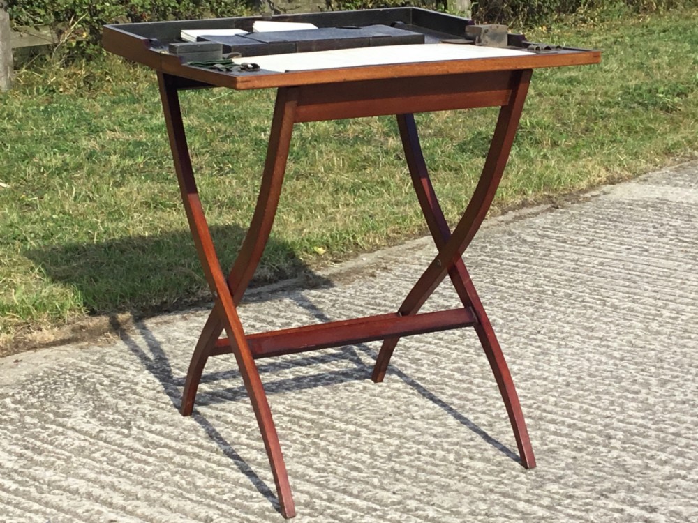 A mahogany folding coaching table with curved X-frame legs and a tray top design. View IX