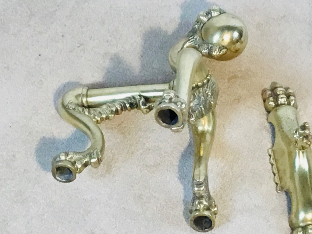 A polished brass fireside suite including a fender, two fire dogs with claw and ball feet, and three matching companion tools. View IV