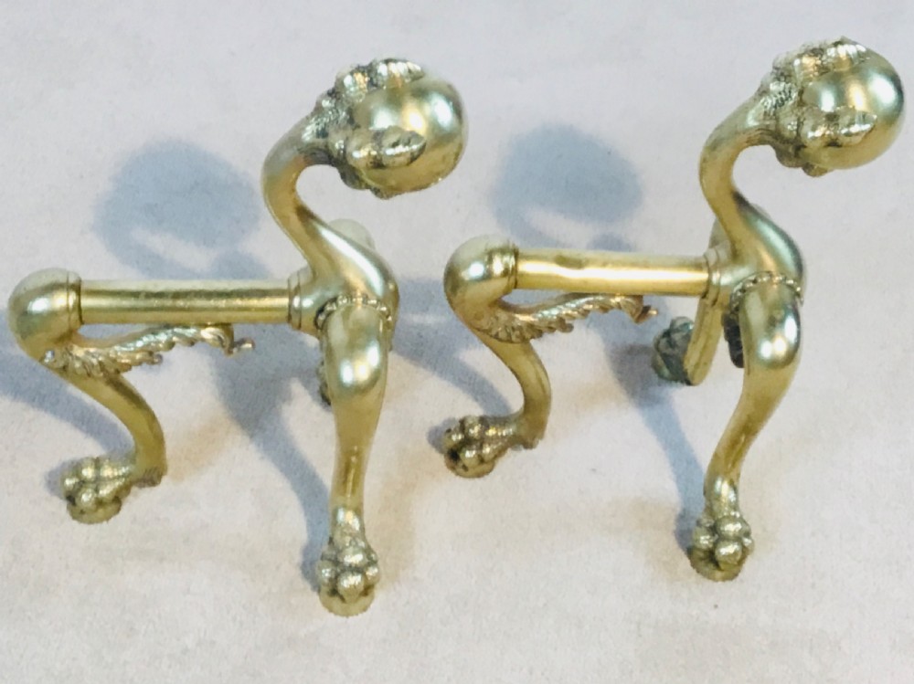 A polished brass fireside suite including a fender, two fire dogs with claw and ball feet, and three matching companion tools. View V