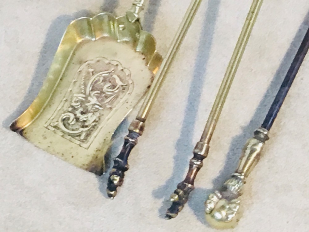 A polished brass fireside suite including a fender, two fire dogs with claw and ball feet, and three matching companion tools. View VI