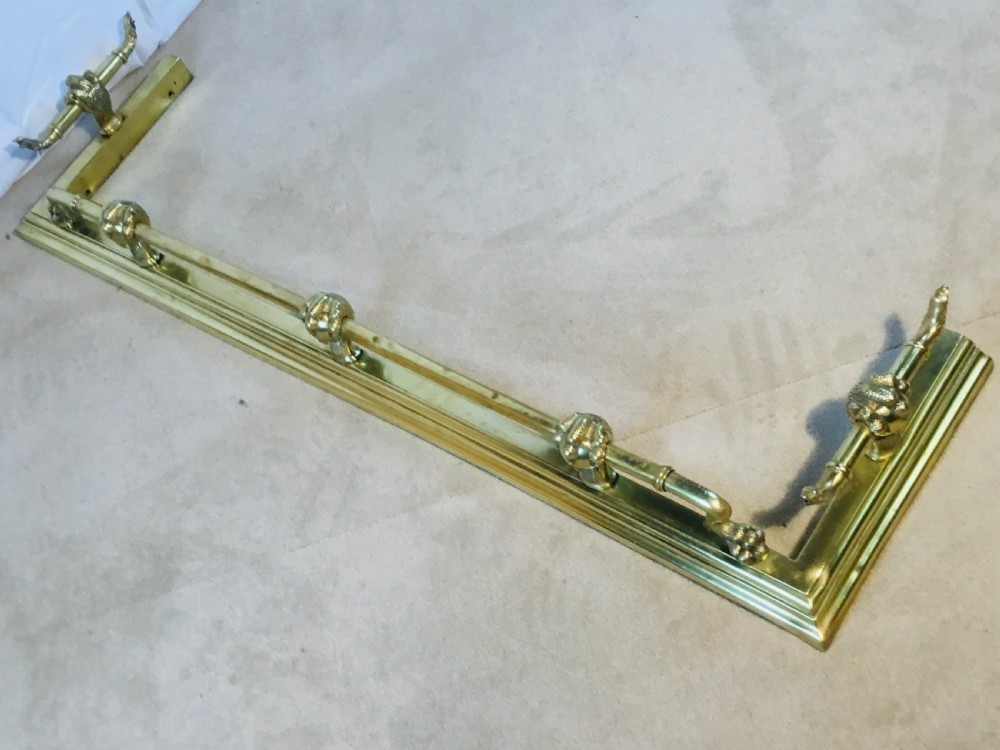 A polished brass fireside suite including a fender, two fire dogs with claw and ball feet, and three matching companion tools. View XI