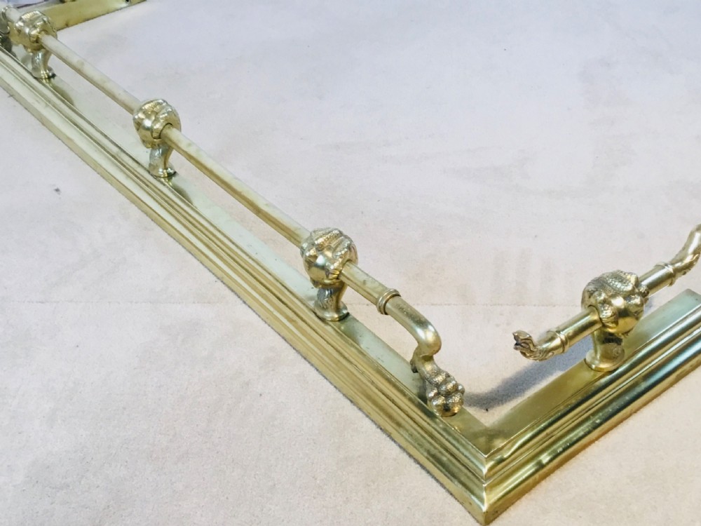 A polished brass fireside suite including a fender, two fire dogs with claw and ball feet, and three matching companion tools. View XIII
