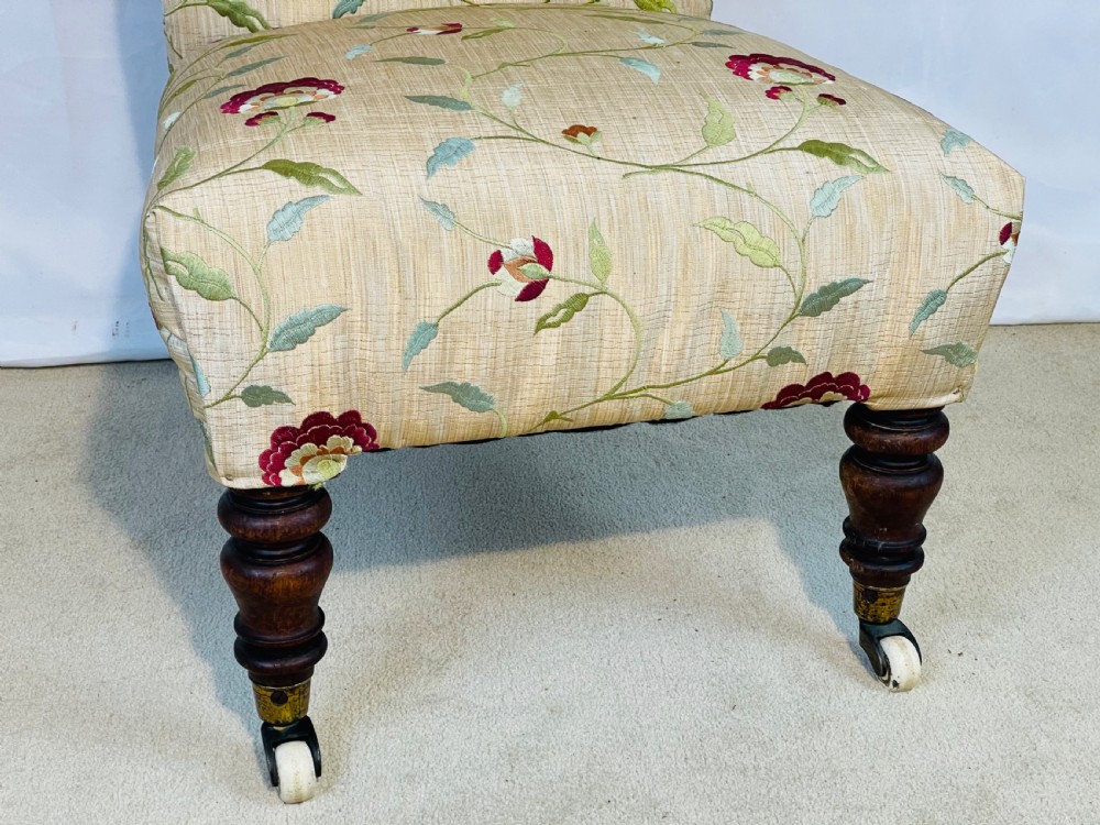A Victorian Prie-Dieu chair featuring button-tufted cream upholstery with floral embroidery, supported on turned dark wood legs with ceramic castors. View XI