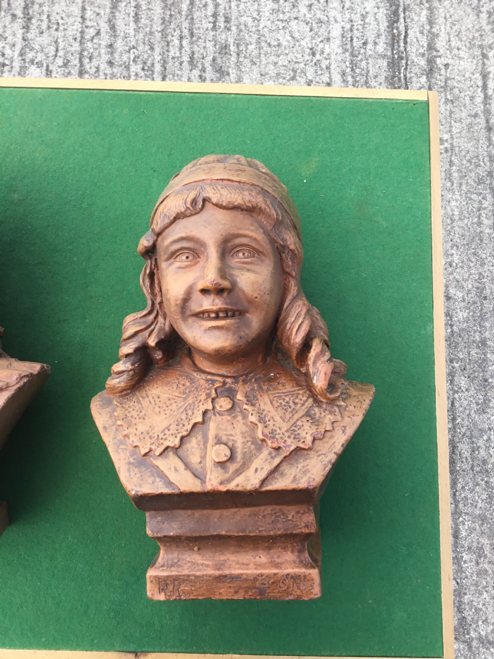 A pair of 19th-century terracotta portrait busts depicting a young boy wearing a cap and a young girl wearing a frilled bonnet. View XIII