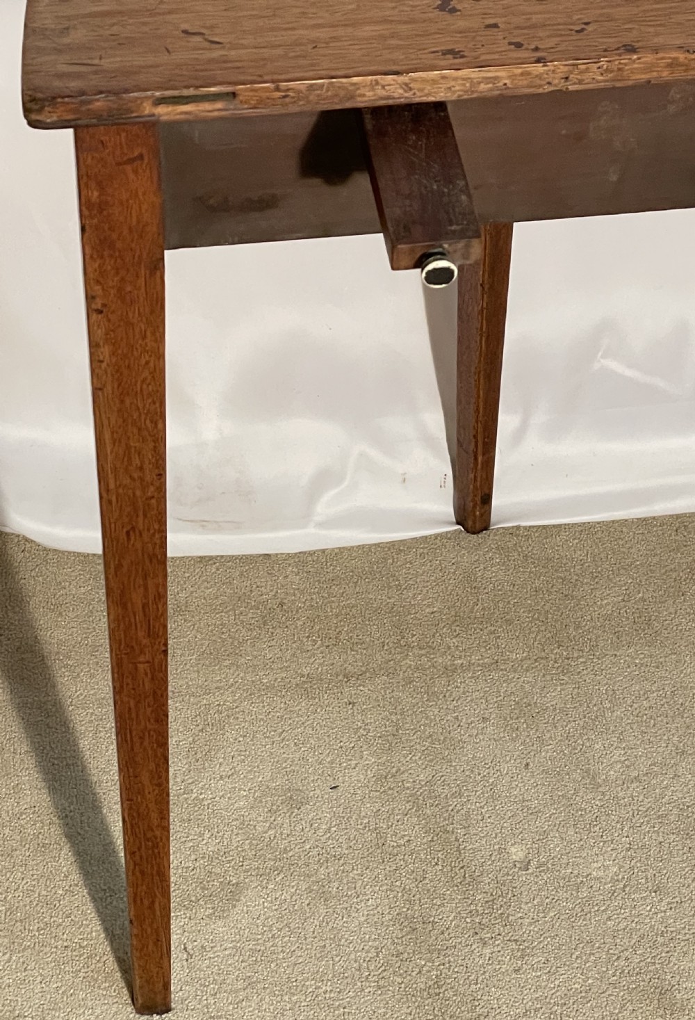 A Georgian mahogany extension dining table featuring a round top assembled from two demi-lune end sections and a central leaf, supported by slender square tapered legs. View VII