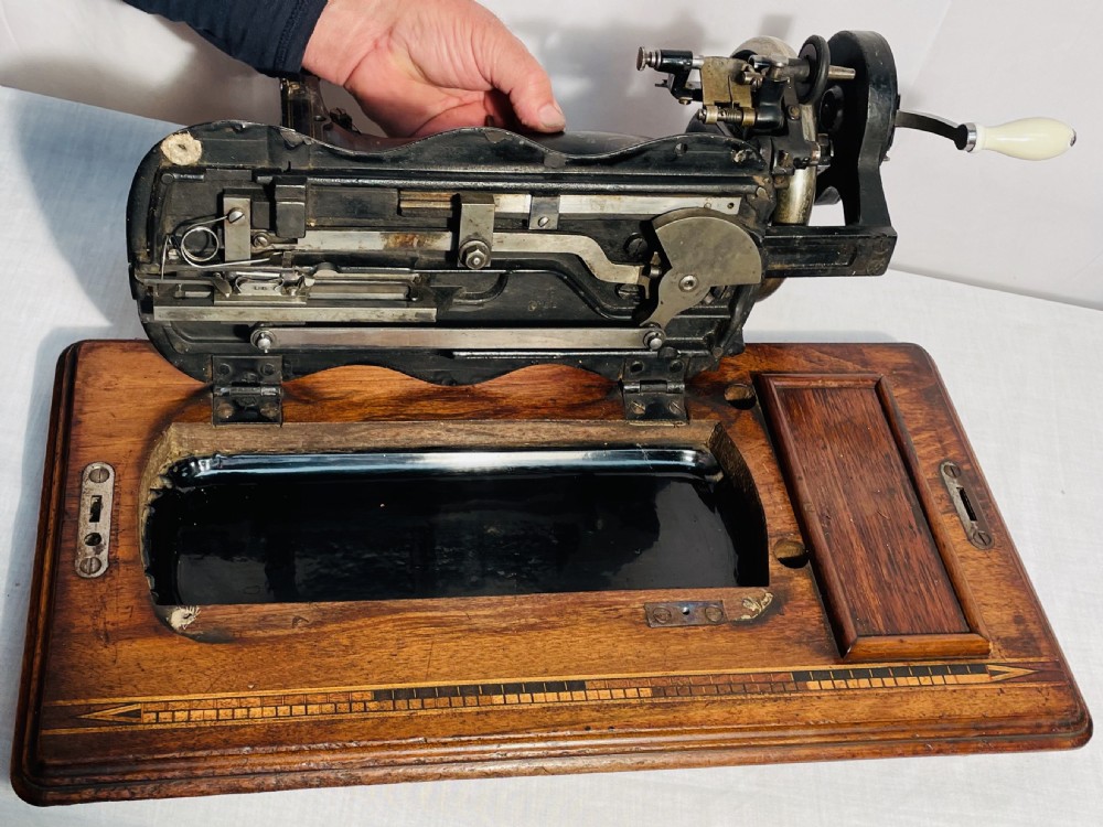 A late nineteenth-century black cast iron Gritzner sewing machine with floral decals mounted on an inlaid wooden base. View XIII