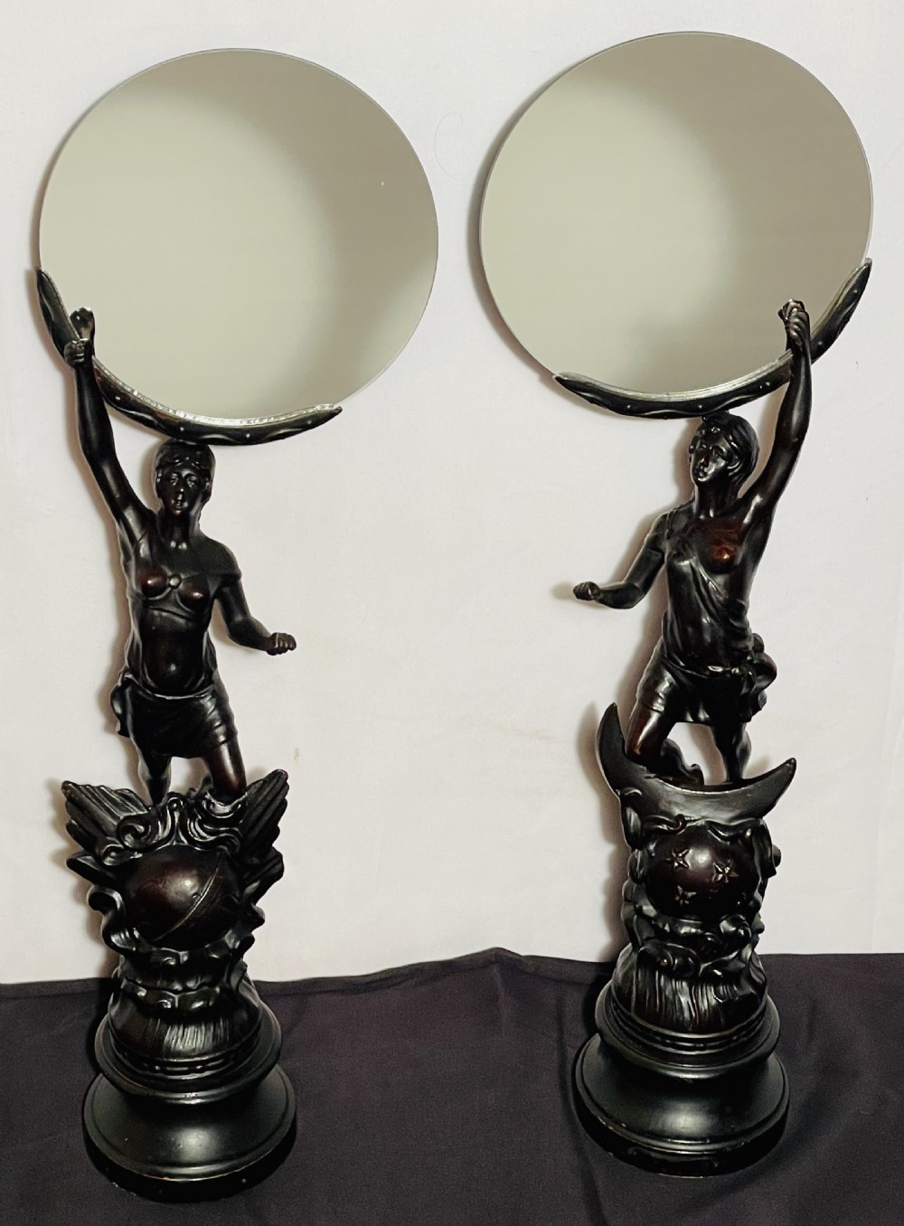 A pair of dark patinated spelter table mirrors featuring classical female figures standing on celestial-themed bases holding circular glass mirrors above their heads. View III