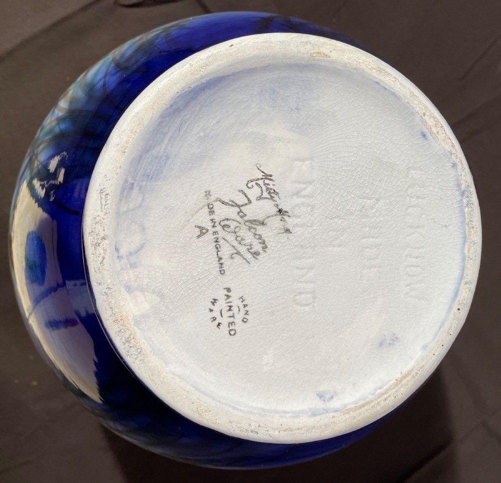 A round blue and grey ceramic vase depicting painted mallard ducks flying over water and reeds. View II