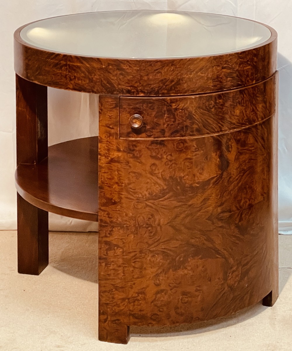 A circular Art Deco occasional table made from rich burr walnut veneer featuring an inset illuminated frosted glass top, curved side door, and lower shelf. View XIII