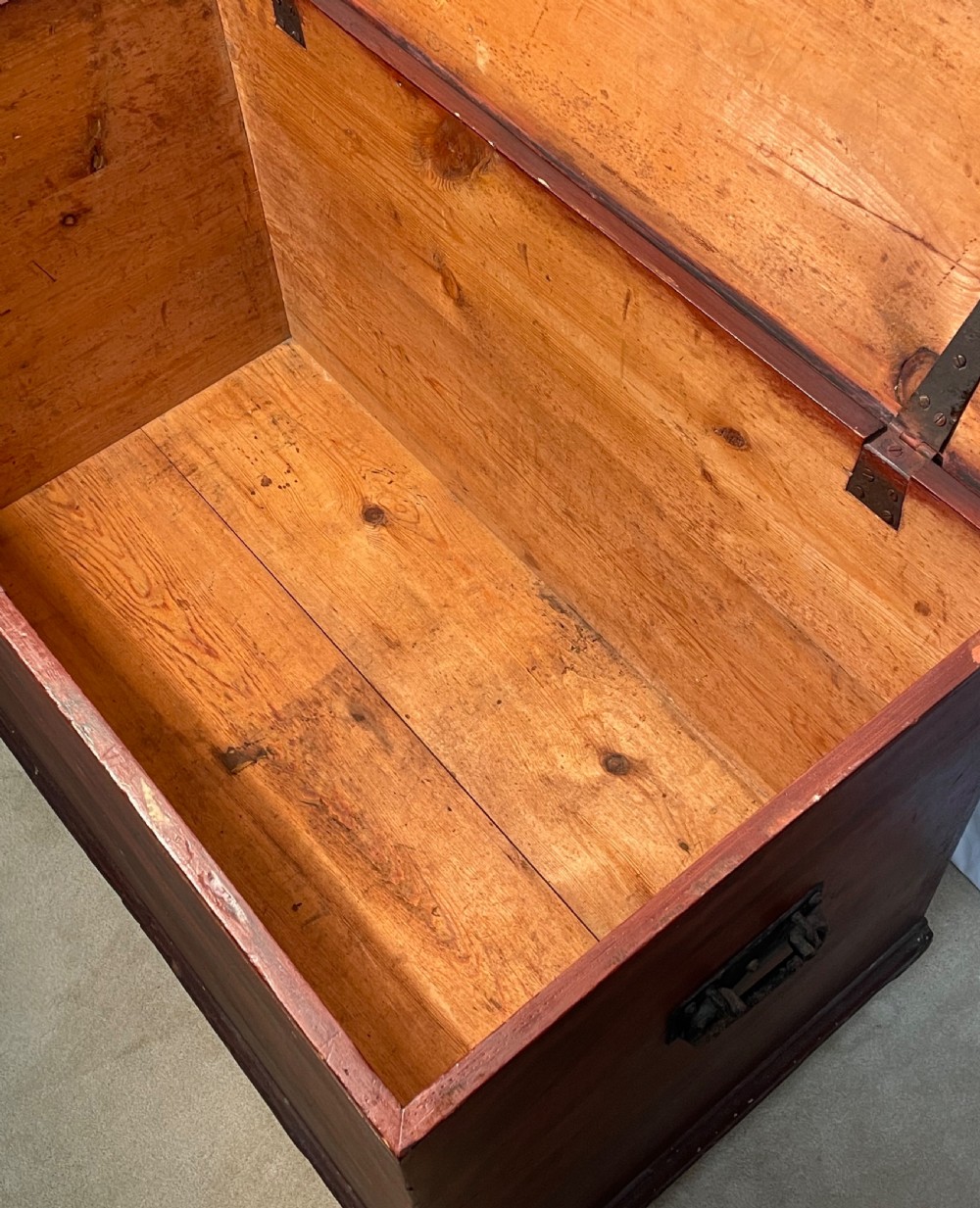A nineteenth-century rectangular pine blanket box with a reddish-brown painted finish, hinged lid, keyhole, and bracket feet. View X