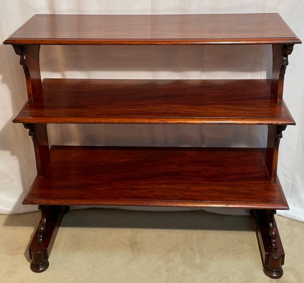 A three-tiered William IV mahogany dumb waiter featuring carved scroll supports with carved roundel details and a polished finish. View IX