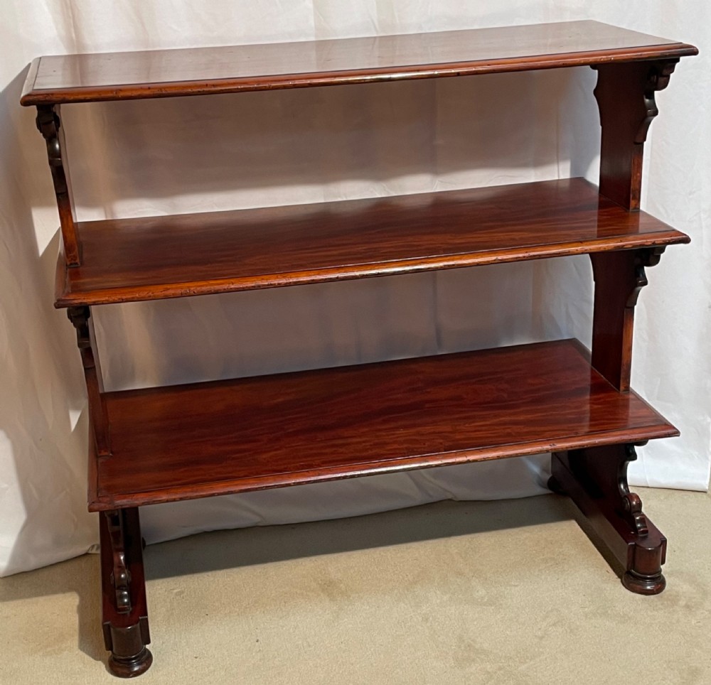 A three-tiered William IV mahogany dumb waiter featuring carved scroll supports with carved roundel details and a polished finish. View XII