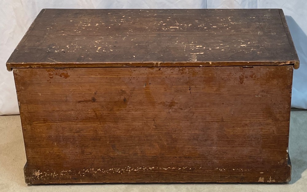 An open antique pine blanket box with a faux-grain painted exterior, exposed internal timber, and iron strap hinges. View XI