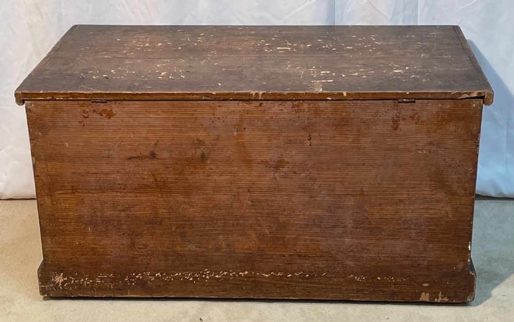 An open antique pine blanket box with a faux-grain painted exterior, exposed internal timber, and iron strap hinges. View XII