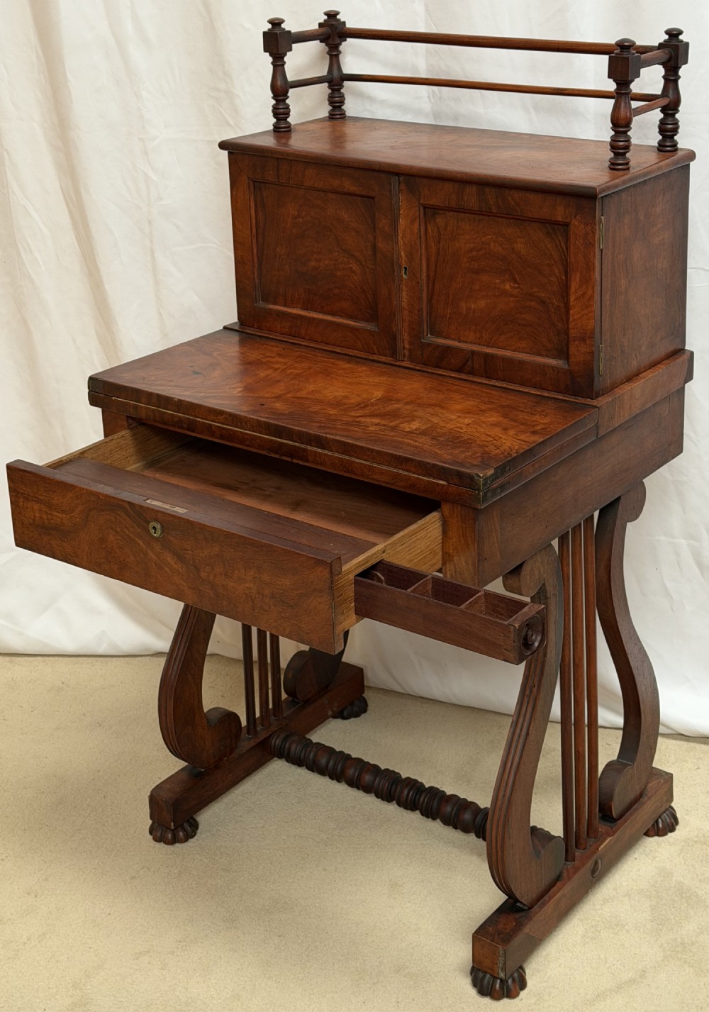 A dark mahogany Regency writing desk featuring twin lyre-shaped end supports, a fold-out leather-lined writing surface, and an upper cabinet with small fitted drawers. View V
