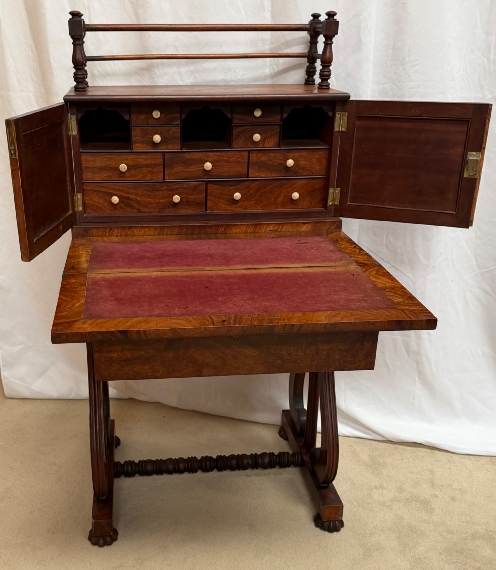 A dark mahogany Regency writing desk featuring twin lyre-shaped end supports, a fold-out leather-lined writing surface, and an upper cabinet with small fitted drawers. View VII