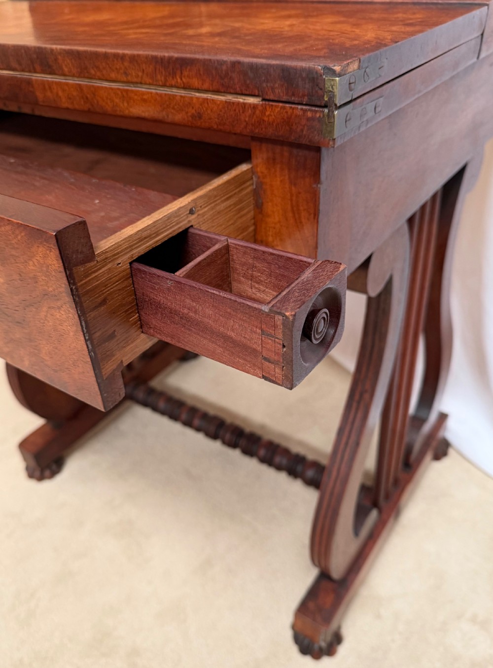 A dark mahogany Regency writing desk featuring twin lyre-shaped end supports, a fold-out leather-lined writing surface, and an upper cabinet with small fitted drawers. View XI