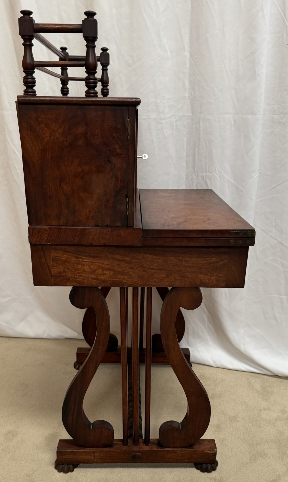 A dark mahogany Regency writing desk featuring twin lyre-shaped end supports, a fold-out leather-lined writing surface, and an upper cabinet with small fitted drawers. View XII