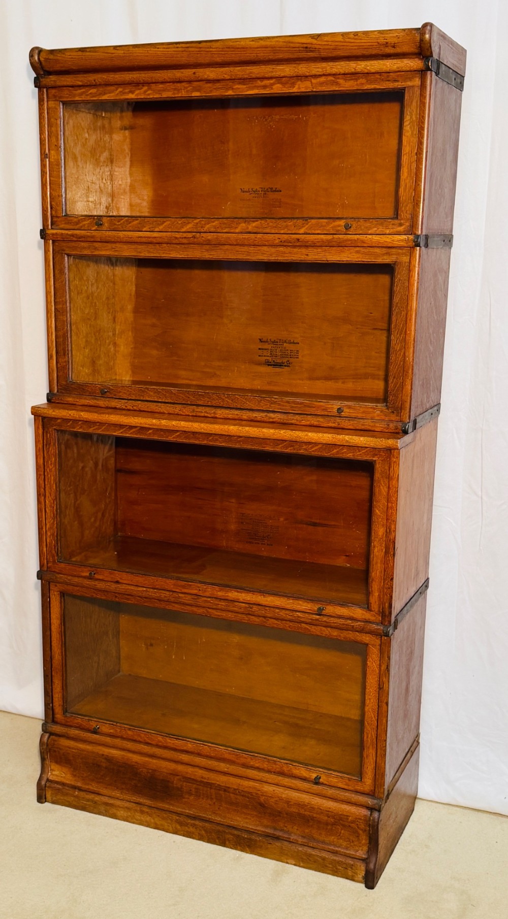 A six-piece antique oak modular barrister bookcase with four glass-fronted lifting doors and metal side straps. View II