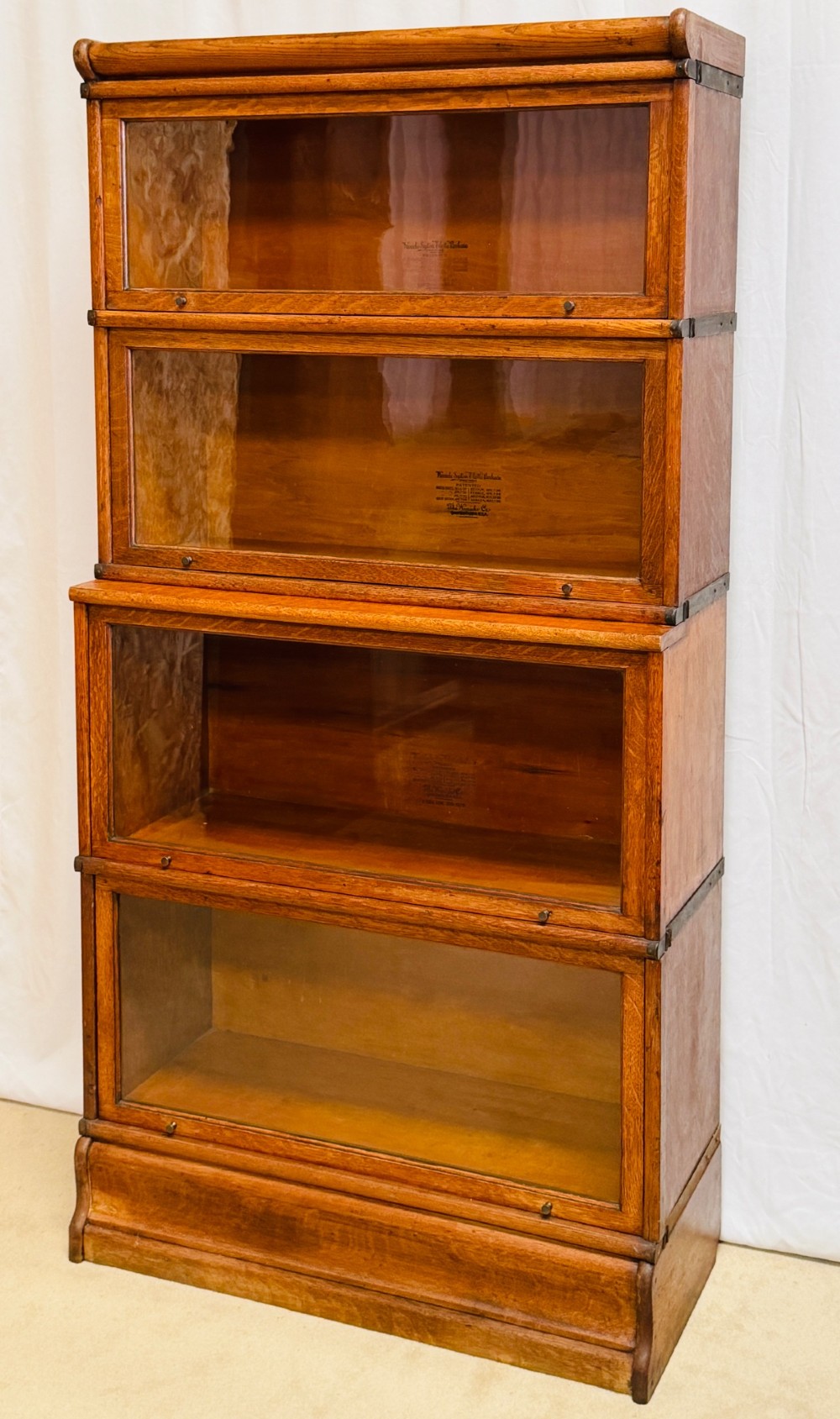 A six-piece antique oak modular barrister bookcase with four glass-fronted lifting doors and metal side straps. View XII