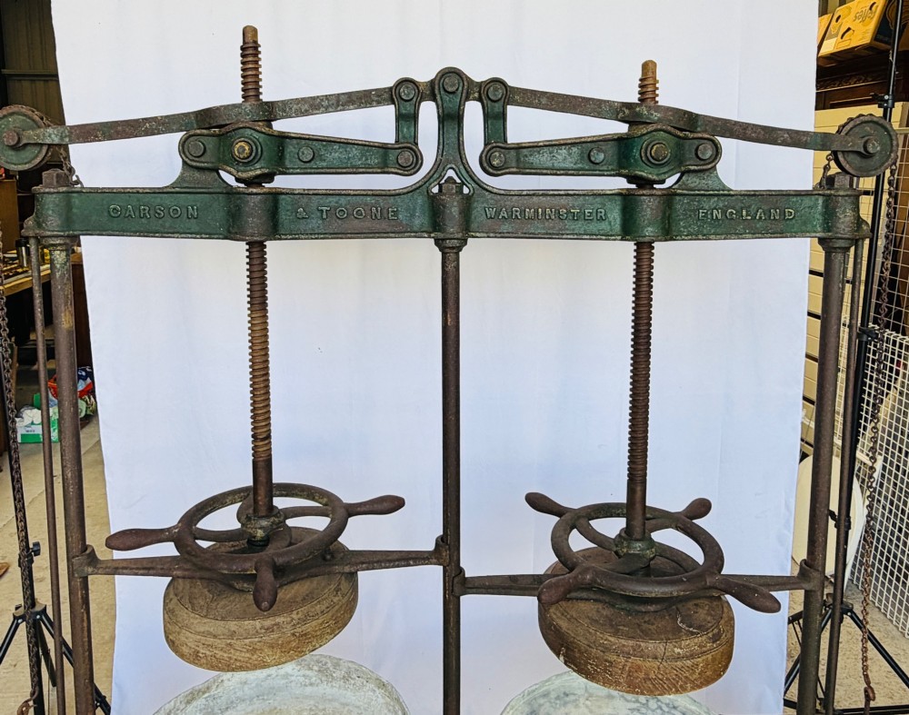 A Victorian double cheese press with a painted dark green cast-iron upper frame, twin screw spindles, and a heavy wooden base structure. View III