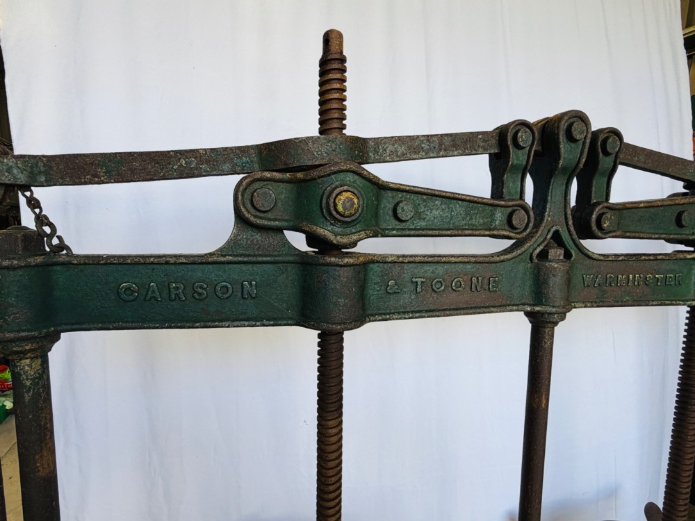 A Victorian double cheese press with a painted dark green cast-iron upper frame, twin screw spindles, and a heavy wooden base structure. View IV