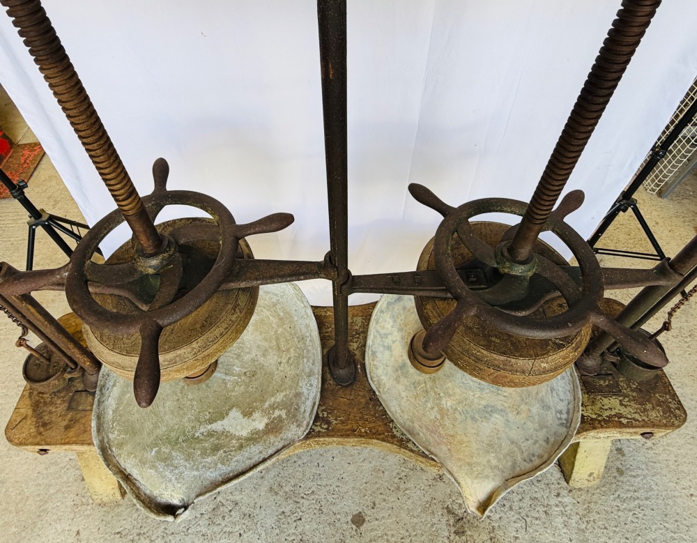 A Victorian double cheese press with a painted dark green cast-iron upper frame, twin screw spindles, and a heavy wooden base structure. View VIII