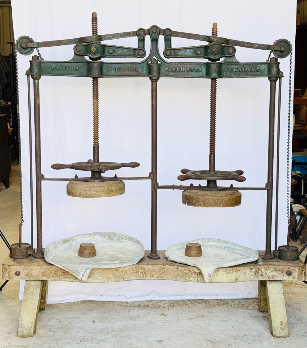 A Victorian double cheese press with a painted dark green cast-iron upper frame, twin screw spindles, and a heavy wooden base structure. View IX