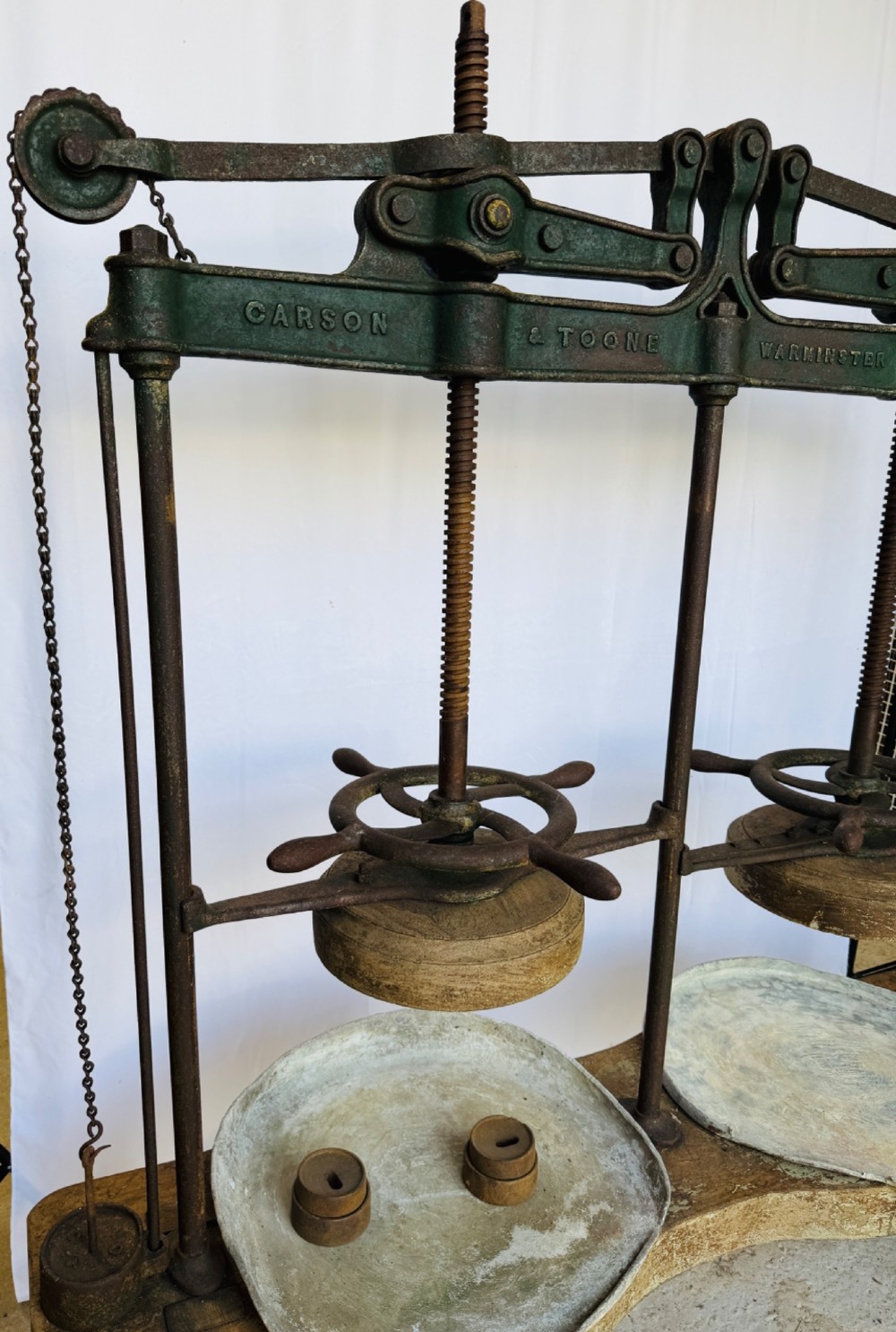 A Victorian double cheese press with a painted dark green cast-iron upper frame, twin screw spindles, and a heavy wooden base structure. View XIII