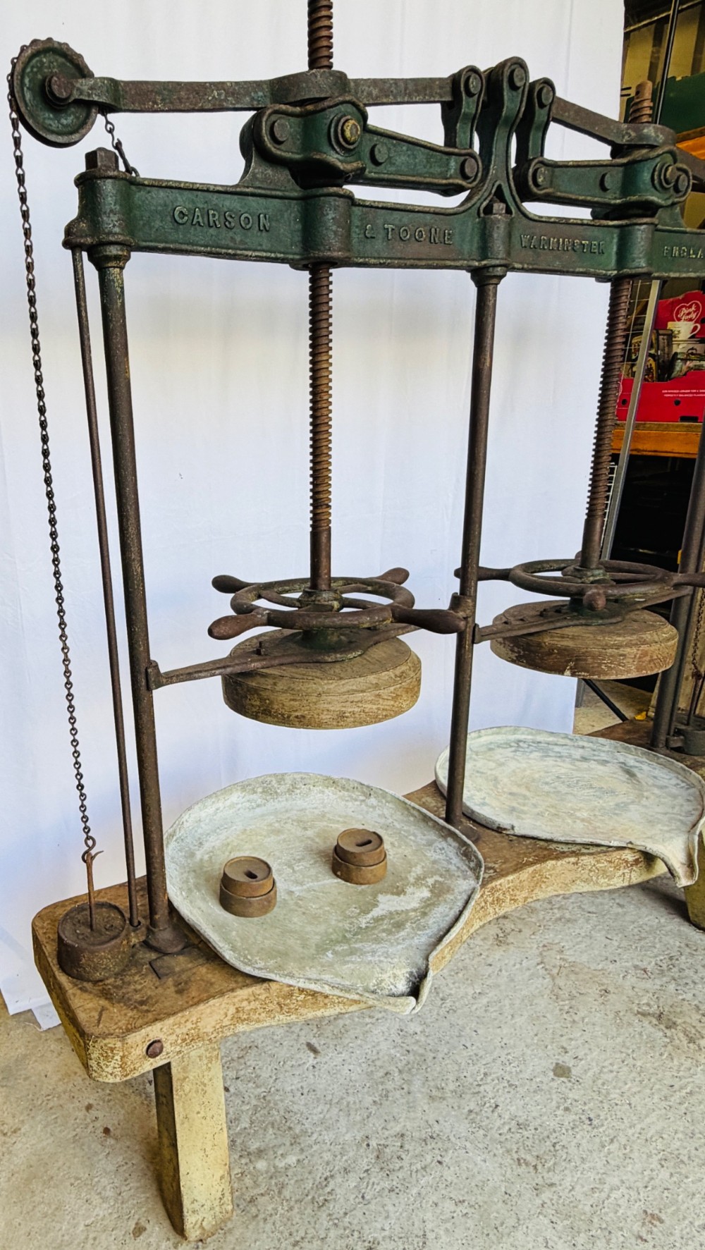 A Victorian double cheese press with a painted dark green cast-iron upper frame, twin screw spindles, and a heavy wooden base structure. View XIV