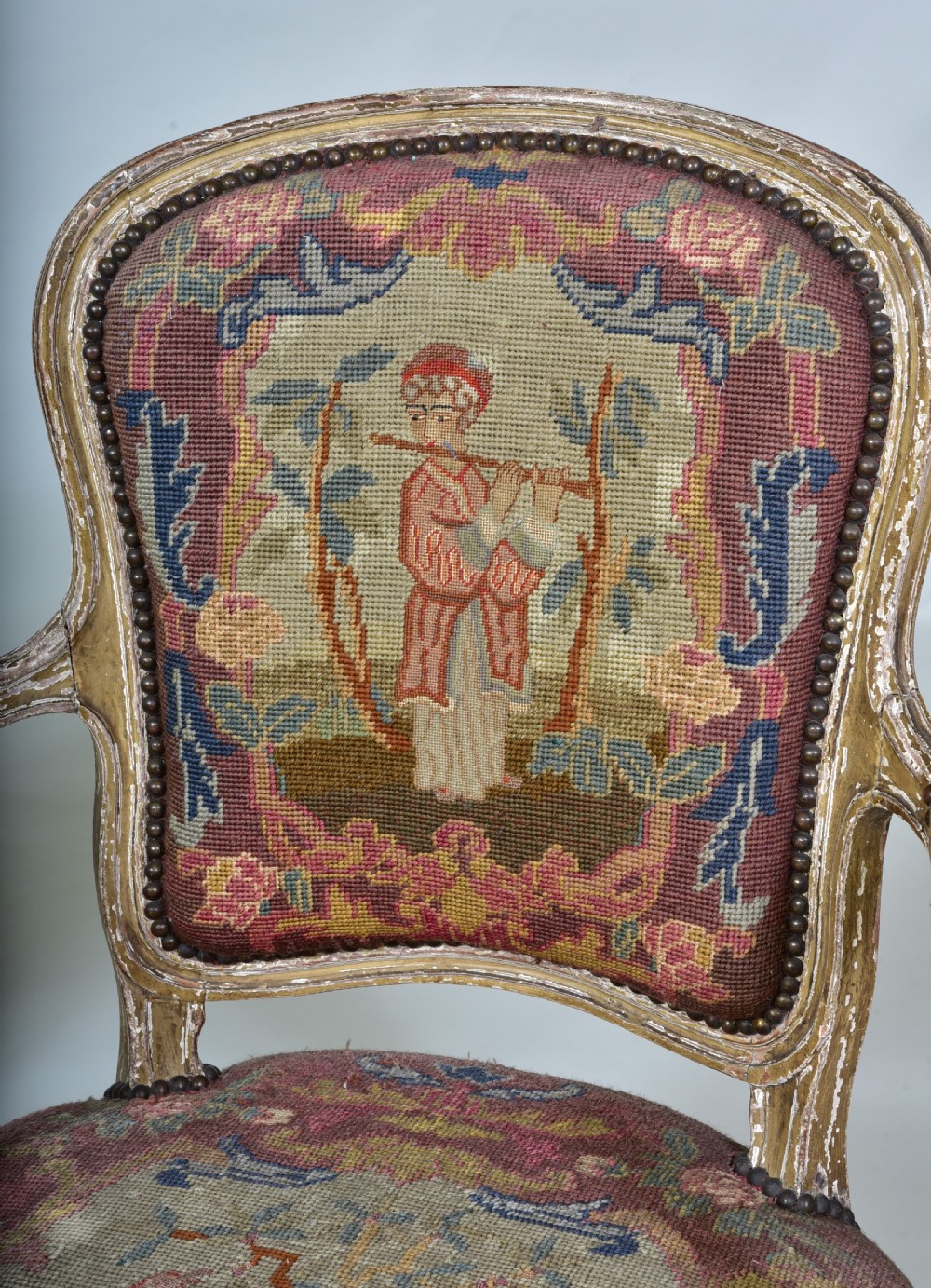 A pair of late 18th-century French painted wood fauteuil armchairs featuring curved cabriole legs and hand-stitched floral and figurative needlework upholstery. View VI