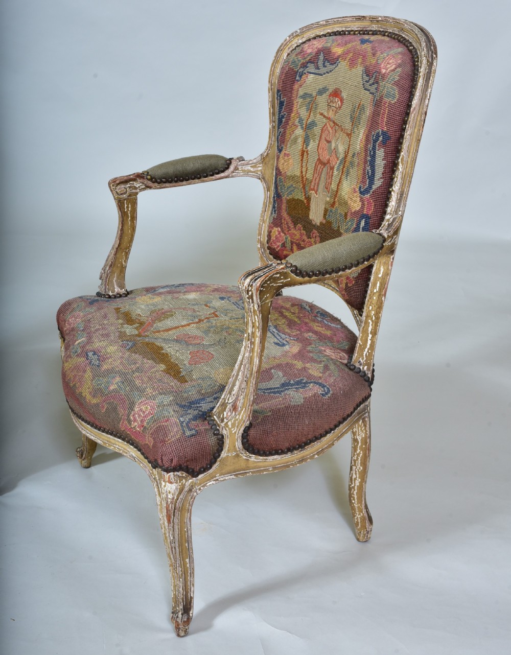 A pair of late 18th-century French painted wood fauteuil armchairs featuring curved cabriole legs and hand-stitched floral and figurative needlework upholstery. View VII