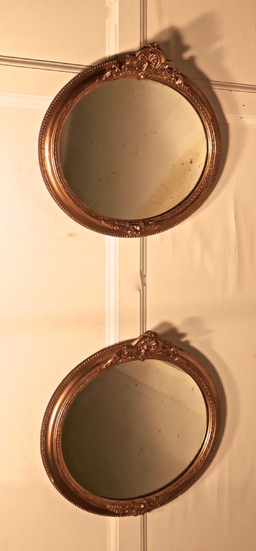 A Rare Pair of 19th Century Regency Style Oval Gilt Mirrors