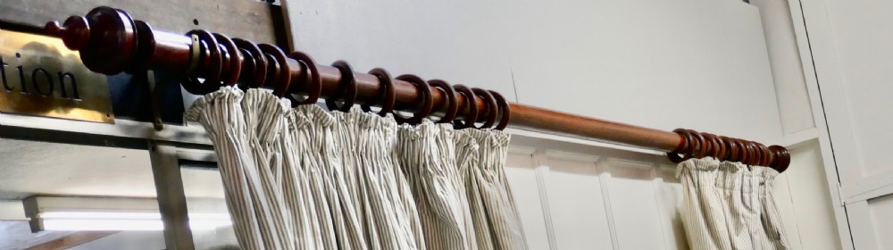 A Very Long Victorian Mahogany Curtain Pole with Rings