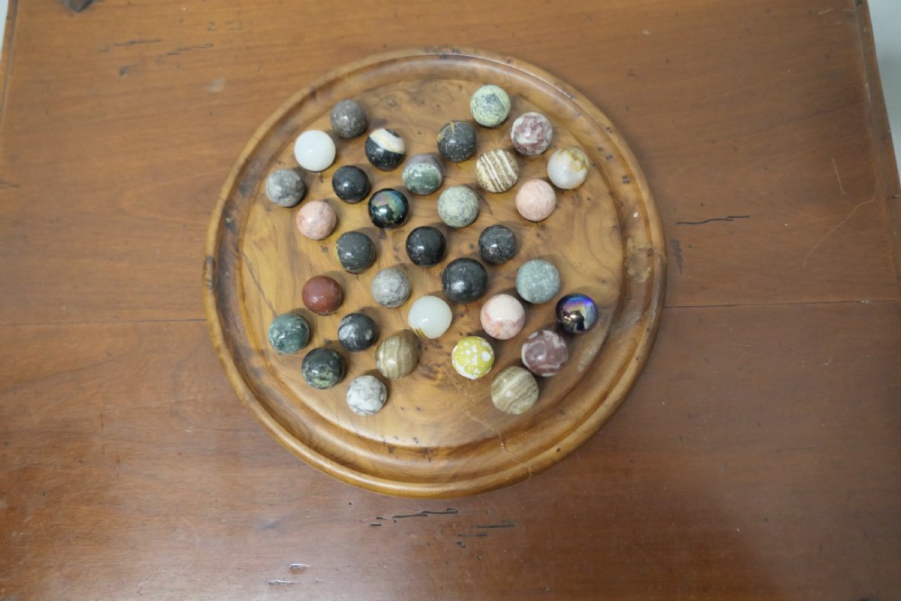 A set of French Marbles on a Turned Solitaire Board