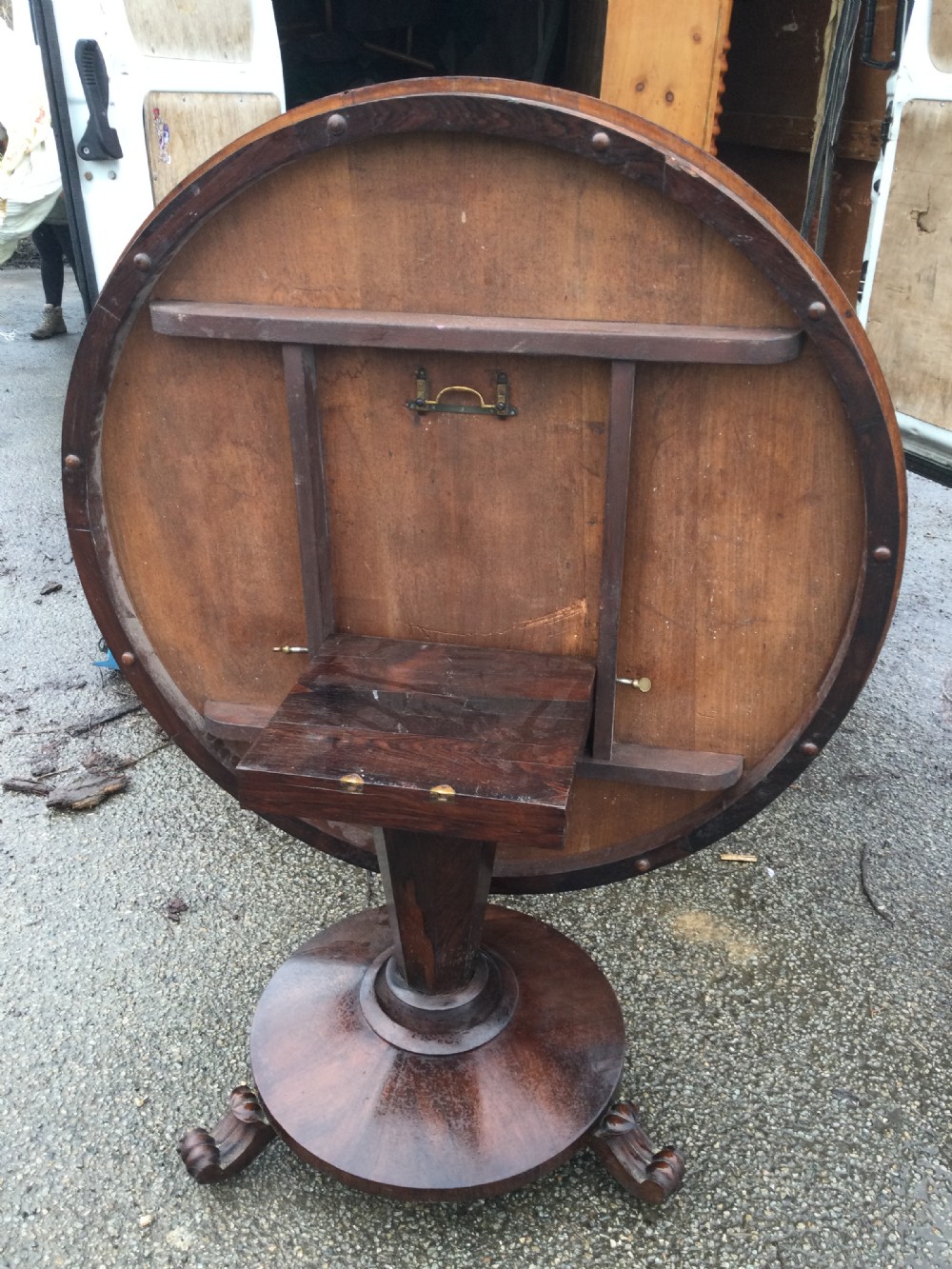 An early Victorian circular rosewood breakfast table featuring a figured timber top on a central pedestal base with carved feet. View IX