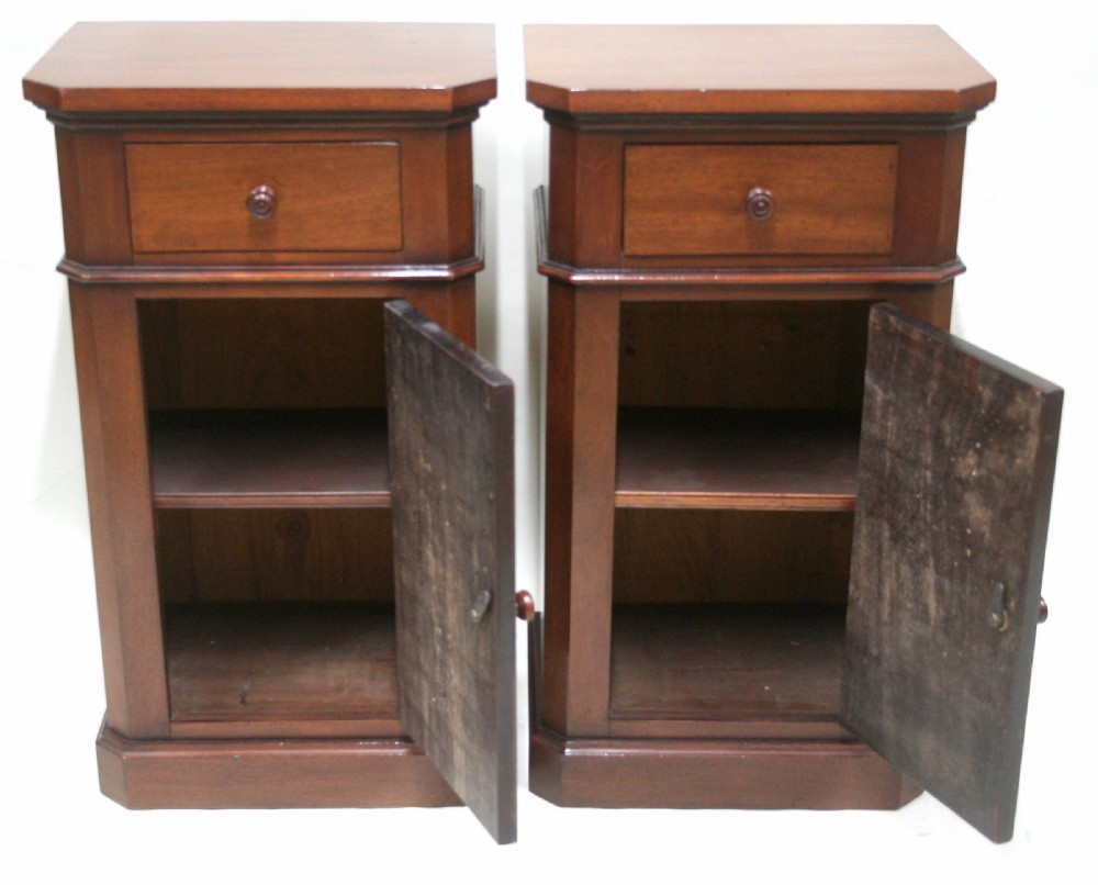 A matching pair of mahogany bedside cabinets featuring canted corners, single top drawers, cupboard doors, turned wooden knobs, and plinth bases. View III