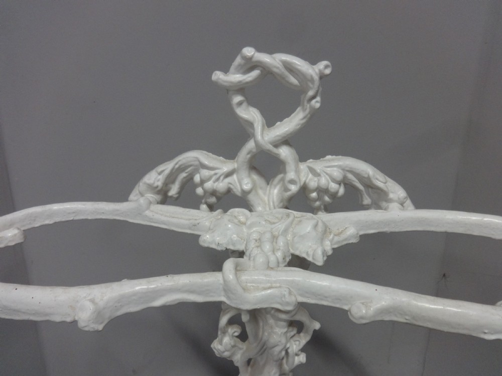 A white painted Victorian cast iron umbrella stand featuring botanical vine motifs and a fitted lower drip tray. View II