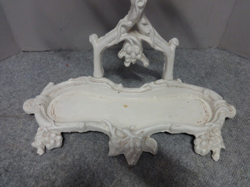 A white painted Victorian cast iron umbrella stand featuring botanical vine motifs and a fitted lower drip tray. View III
