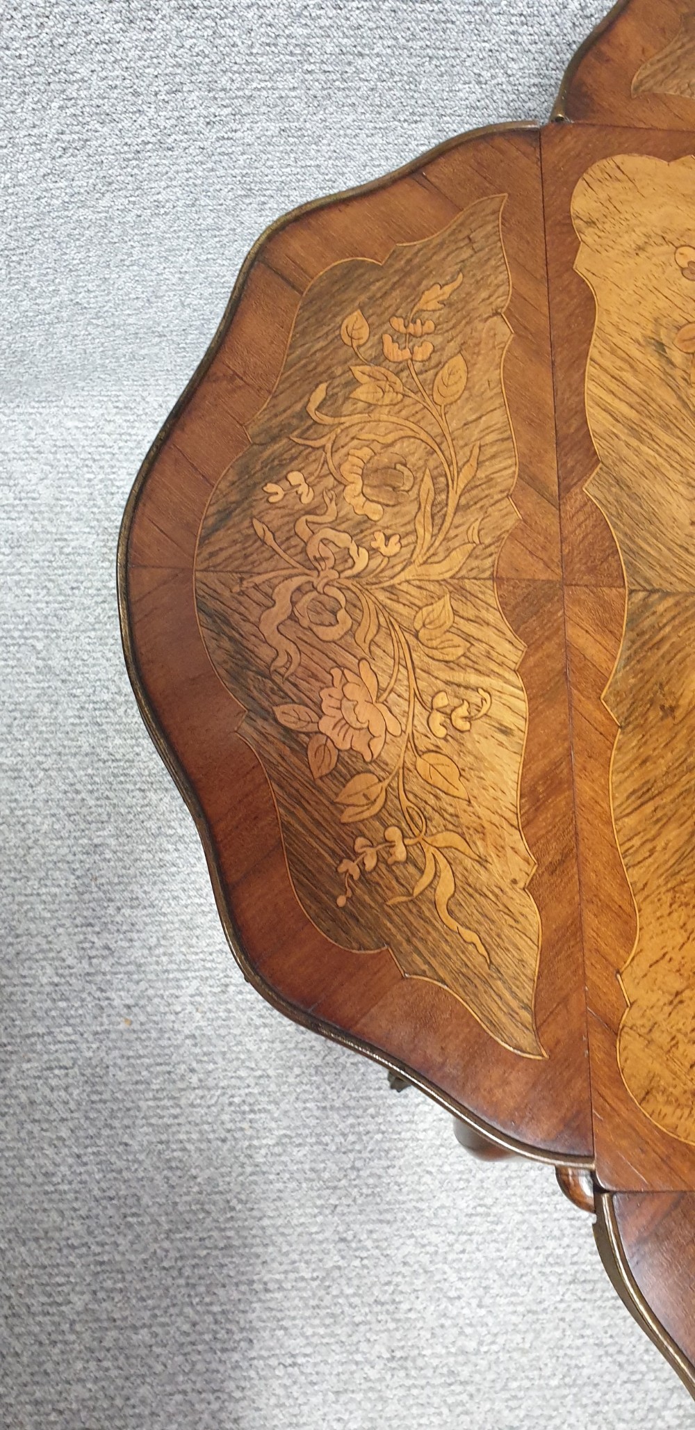 A warm brown wooden drop-flap side table featuring floral marquetry inlay, slender cabriole legs, and brass foot mounts. View IX