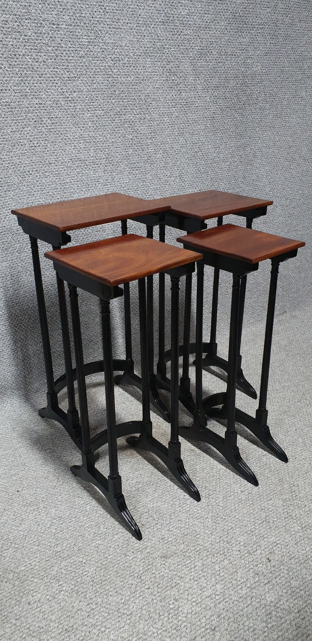 A set of four graduated mahogany nesting tables featuring rectangular tops, slender turned legs, and trestle feet. View III