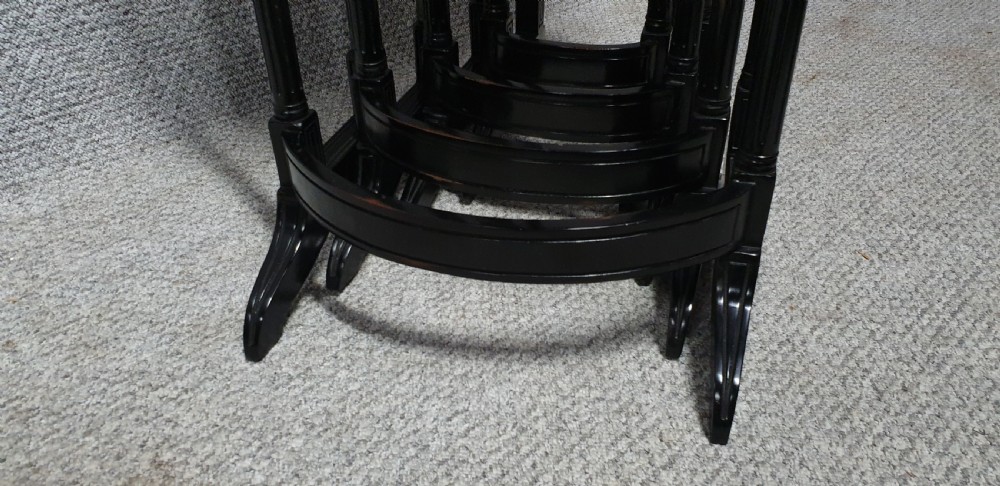 A set of four graduated mahogany nesting tables featuring rectangular tops, slender turned legs, and trestle feet. View V
