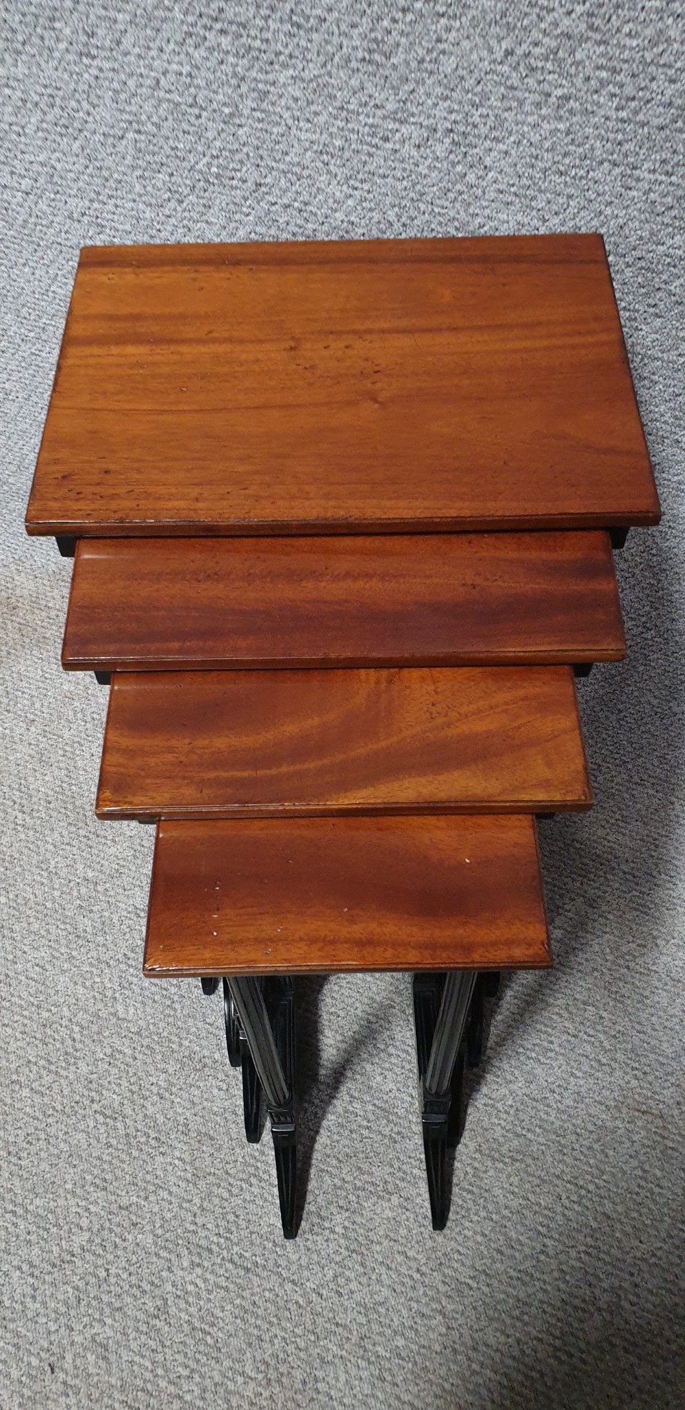 A set of four graduated mahogany nesting tables featuring rectangular tops, slender turned legs, and trestle feet. View VII