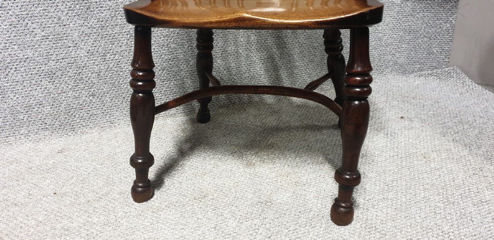 An antique yew wood Windsor armchair featuring a hoop back with vertical spindles, a decorative pierced central splat, a contoured seat, and turned legs. View II