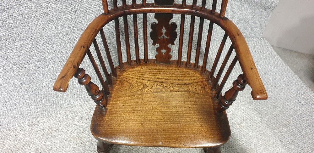 An antique yew wood Windsor armchair featuring a hoop back with vertical spindles, a decorative pierced central splat, a contoured seat, and turned legs. View III