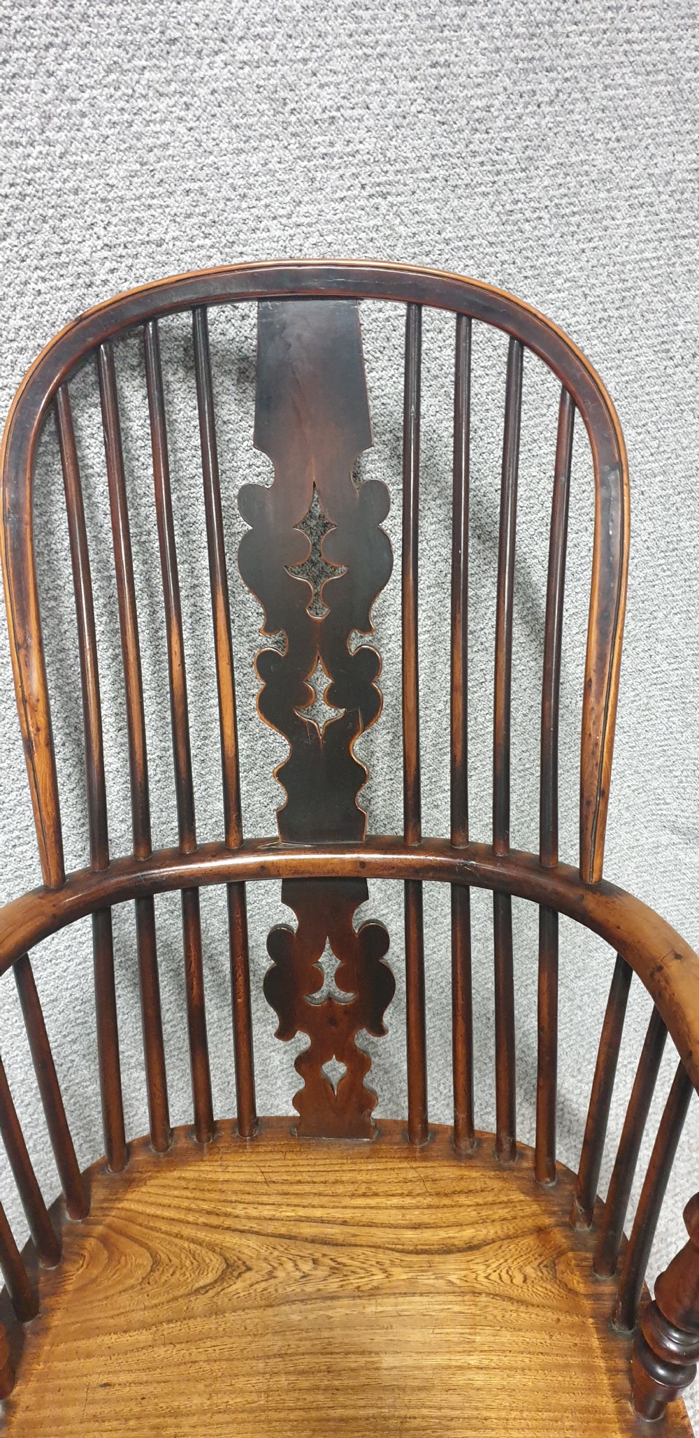 An antique yew wood Windsor armchair featuring a hoop back with vertical spindles, a decorative pierced central splat, a contoured seat, and turned legs. View IV