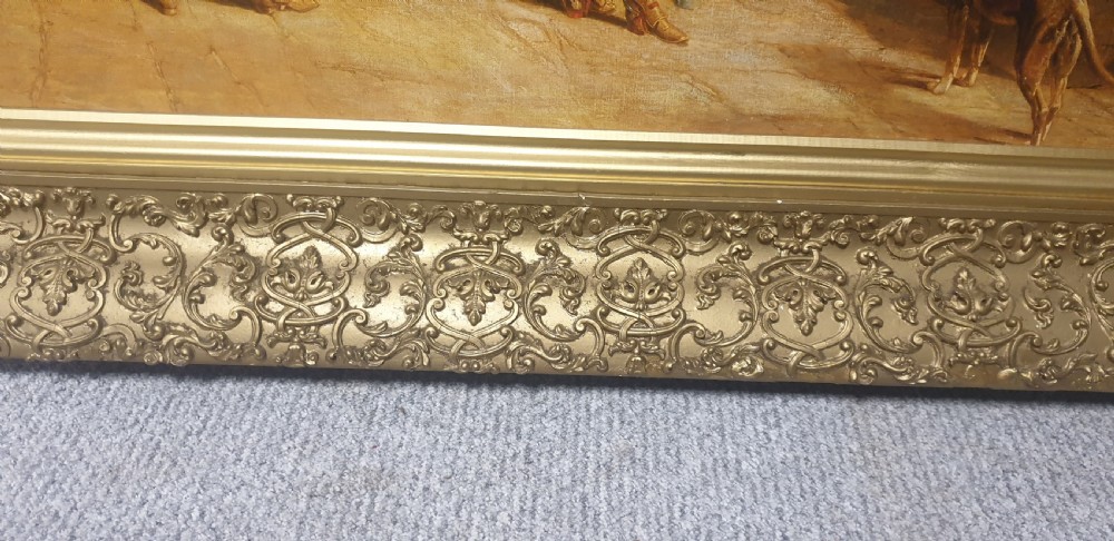 A large Victorian gilded picture frame with ornate relief moulding containing a historical narrative print. View VII