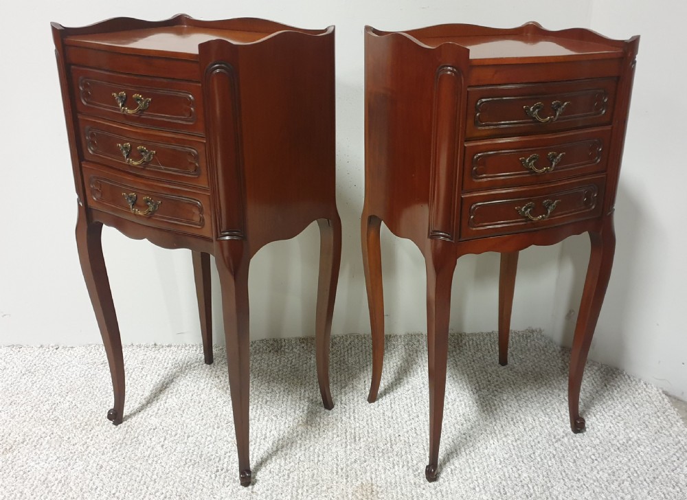 A matching pair of tall French mahogany bedside chests featuring three drawers with brass handles and slender cabriole legs. View VI